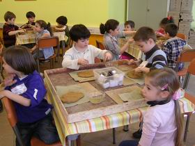 Bambini che fanno una maschera con la creta